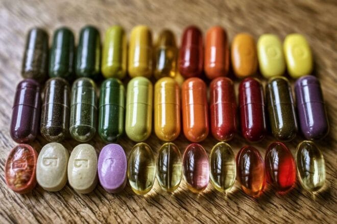 Assortiment de compléments alimentaires colorés sur une table en bois