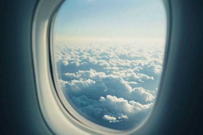 Gros plan d un hublot d avion avec des nuages et lumière du soleil
